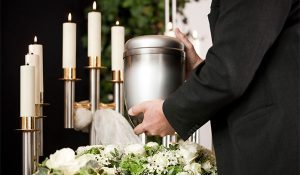Man holding urn with cremated remains at crematorium ceremony